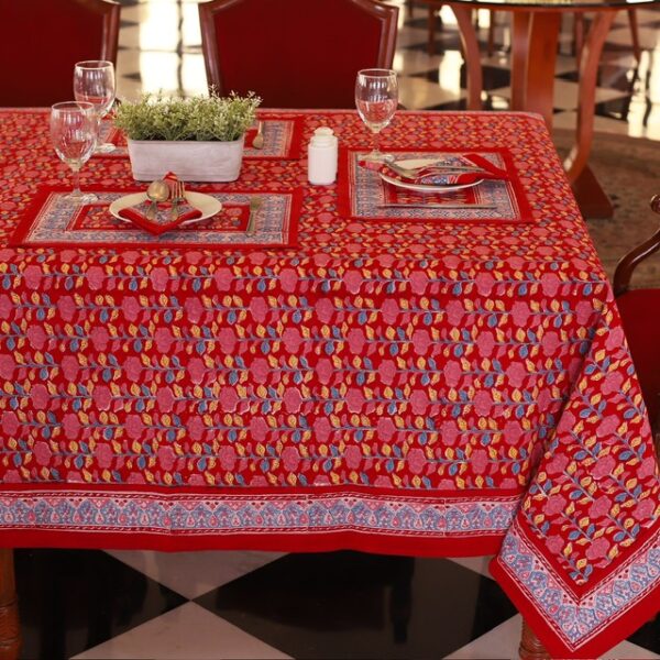 Nappe Maharaja Feast rouge avec des motifs floraux abstraits en nuances de bleu et de jaune, évoquant une ambiance festive et luxueuse.