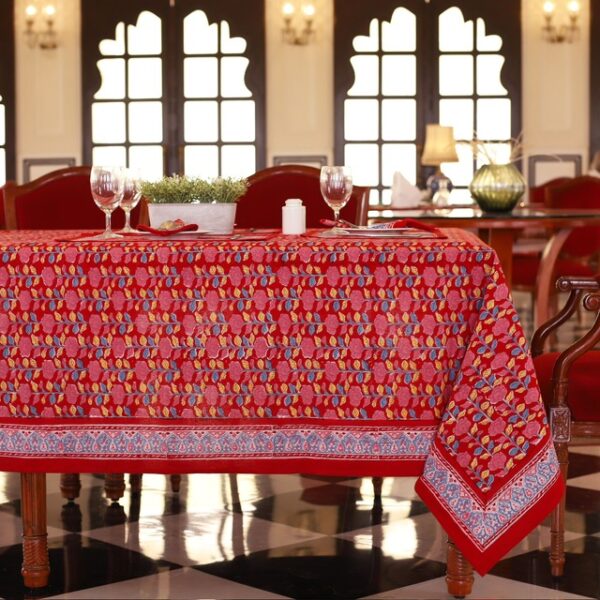 Nappe Maharaja Feast rouge avec des motifs floraux abstraits en nuances de bleu et de jaune, évoquant une ambiance festive et luxueuse.