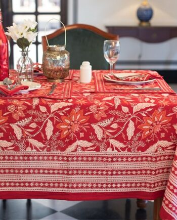 Nappe artisanale Sari Écarlate en coton, rouge vif avec des motifs floraux imprimés à la main, dressée sur une table élégante avec vaisselle et décoration raffinée.