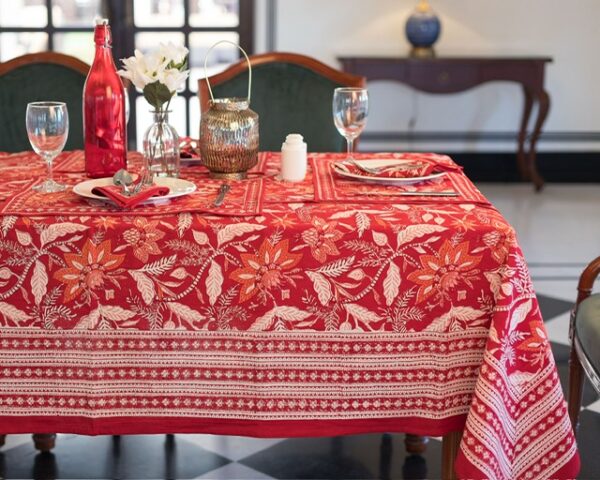 Nappe artisanale Sari Écarlate en coton, rouge vif avec des motifs floraux imprimés à la main, dressée sur une table élégante avec vaisselle et décoration raffinée.