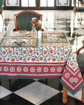 Nappe Rajasthan Royal en coton blanc avec motifs floraux rouges, jaunes et verts, imprimée à la main selon la technique du block print, posée sur une table élégante.