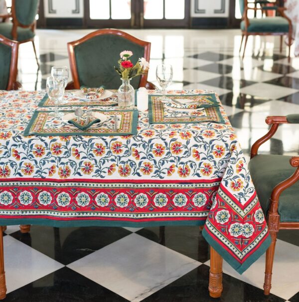 Nappe Rajasthan Royal en coton blanc avec motifs floraux rouges, jaunes et verts, imprimée à la main selon la technique du block print, posée sur une table élégante.