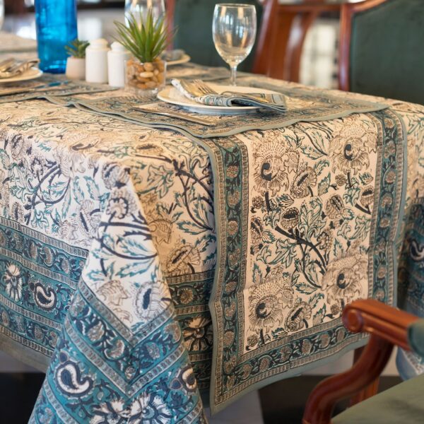 Nappe Kerala Dream en coton, imprimée à la main avec des motifs floraux en bleu et vert, posée sur une table élégamment dressée.