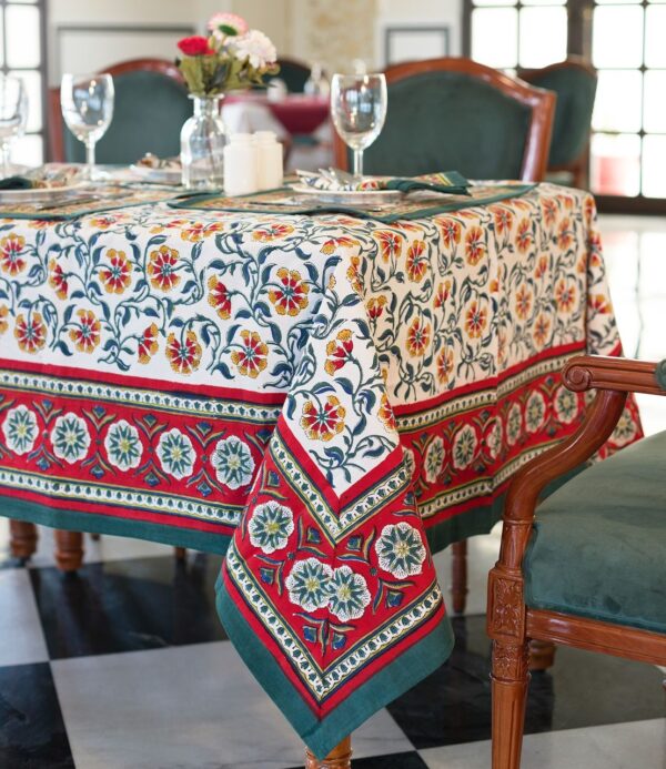 Nappe Rajasthan Royal en coton blanc avec motifs floraux rouges, jaunes et verts, imprimée à la main selon la technique du block print, posée sur une table élégante.