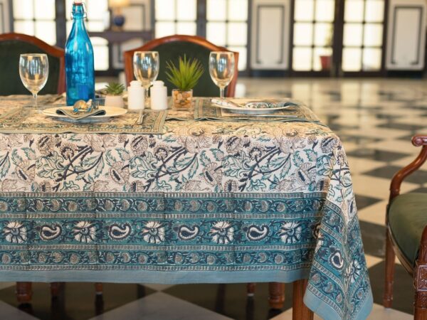 Nappe Kerala Dream en coton, imprimée à la main avec des motifs floraux en bleu et vert, posée sur une table élégamment dressée.