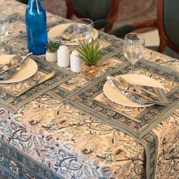 Nappe Kerala Dream en coton, imprimée à la main avec des motifs floraux en bleu et vert, posée sur une table élégamment dressée.