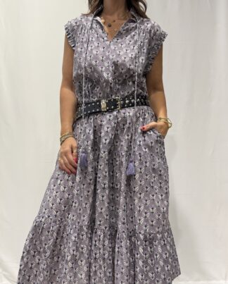 Robe Chandra Mauve - Femme portant une robe longue sans manches à imprimé floral, avec volants et liens à pompons, coupe ample et col tunisien.