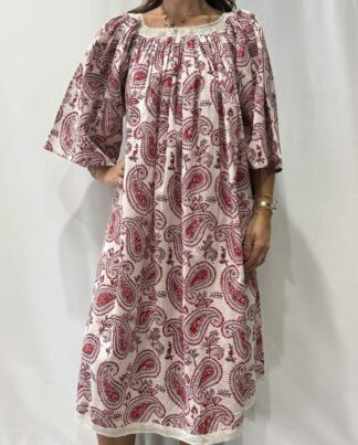 Robe Sita Blanche Framboise -Femme portant une robe ample en coton blanc et rouge framboise à imprimé floral, manches larges et col smocké en dentelle