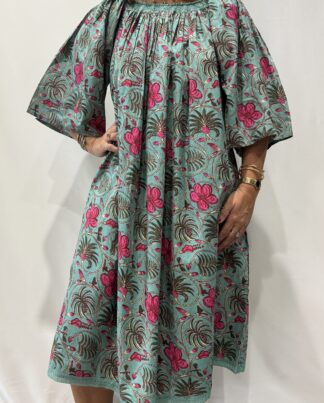 Robe Sita Verte Rose -Femme portant une robe ample en coton vert et rose à imprimé floral, manches larges et col smocké en dentelle