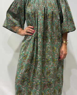 Robe Sita Verte -Femme portant une robe ample en coton vert et rose à imprimé floral, manches larges et col smocké en dentelle