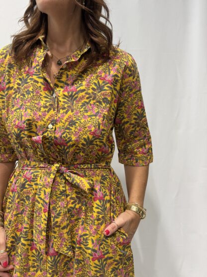 Robe Soraya Jaune Fleurie - Femme portant une robe chemise longue à imprimé cachemire, avec col boutonné, manches mi-longues et ceinture à la taille.