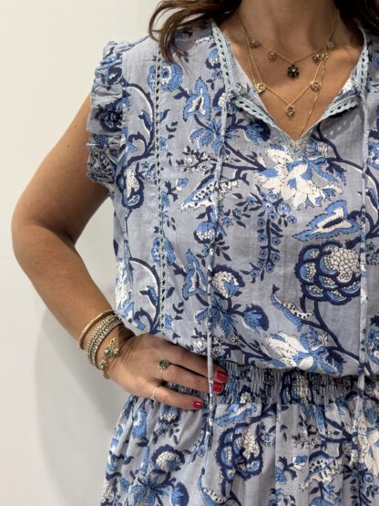Robe Udaipur Bleu : robe courte en coton bleu gris, imprimée de fleurs indigo, avec manches à volants et taille élastique, inspirée de l’artisanat indien.