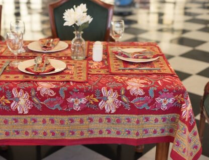 Nappe Maharani Glow rectangulaire 180x340, motifs floraux colorés sur fond rouge, décor de table élégant.