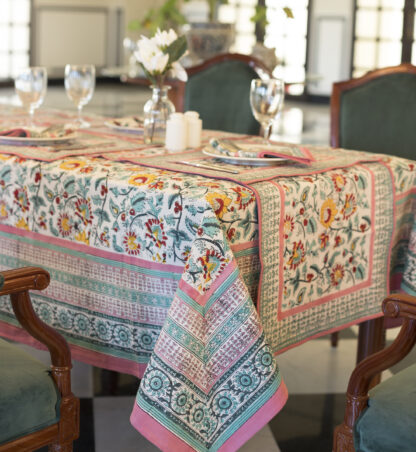 Nappe Dalia rectangulaire, motifs floraux colorés sur fond clair, finitions roses et vertes, décor de table raffiné. Taille : 150 x 230 et 180 x 340