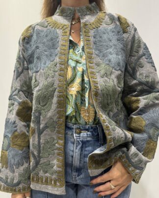 Veste Kamala de Micasasté pour femme, brodée de motifs verts, bleus et kaki sur fond bleu gris.