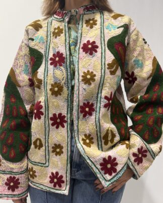 Veste Kiara de Micasasté pour femme, brodée de fleurs bordeau et kaki clair et de paons vert foncé, bordeau et kaki sur fond rose pâle.