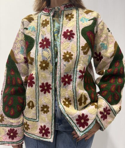 Veste Kiara de Micasasté pour femme, brodée de fleurs bordeau et kaki clair et de paons vert foncé, bordeau et kaki sur fond rose pâle.