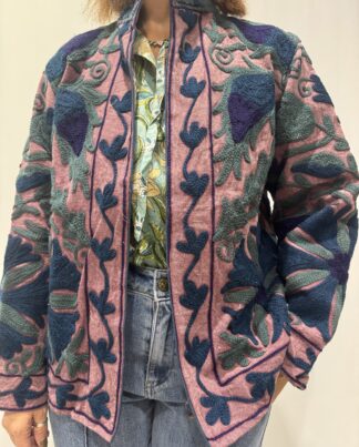 Veste Lalita de Micasasté pour femme, brodée, fond vieux rose, ornée de motifs végétaux bleu foncé, vert et violet, coupe droite et manches longues.
