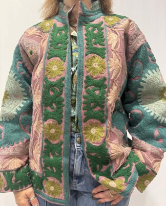 Veste Padmika Micasasté portée de face, de couleurs terracota avec broderies florales vert clair et vert foncé, bleu clair et rose pâle.