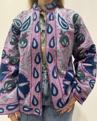 Veste Samira Micasasté portée de face, en coton mauve avec des broderies florales bleu marine, bleu et bleu gris. Une veste courte en Suzani, manches longues et col mao.