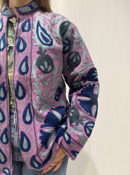 Veste Samira Micasasté vue de côté gauche, broderies florales détaillées en tons de bleu et un fond mauve. Une veste courte, manches longues et col mao.