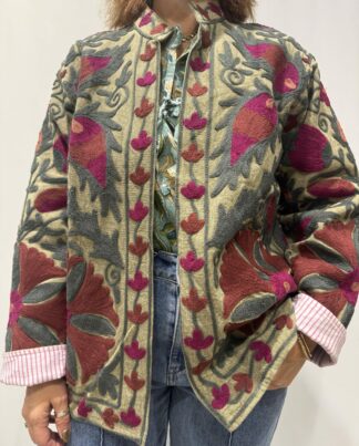 Veste Sha Micasasté portée de face, en coton kaki avec broderies Suzani terracota, prune et kaki foncé, une veste courte au col mao et manches longues.