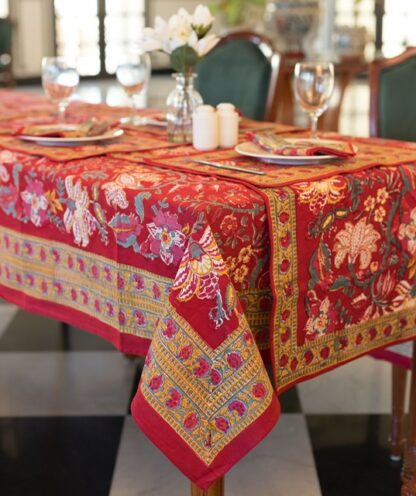 Nappe Maharani Glow rectangulaire 180x340, motifs floraux colorés sur fond rouge, décor de table élégant.