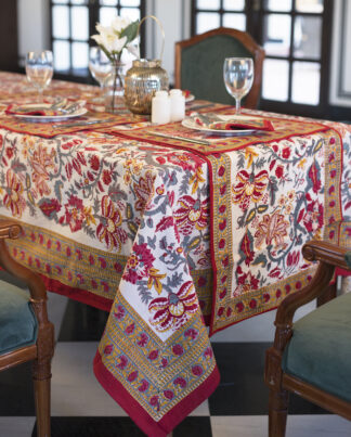 Nappe Lavanya, une nappe sur fond blanc ornée de motifs fleurie de couleurs rouge, bleu et jaune
