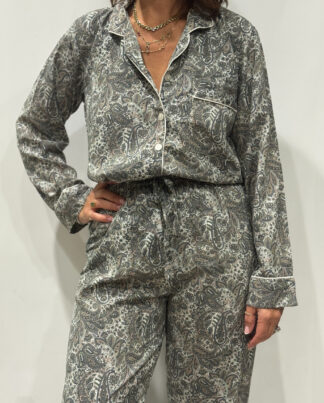 Stéphanie portant le pyjama Mira en soie aux teintes bleu-gris, vert clair et rose poudré, vue de face.