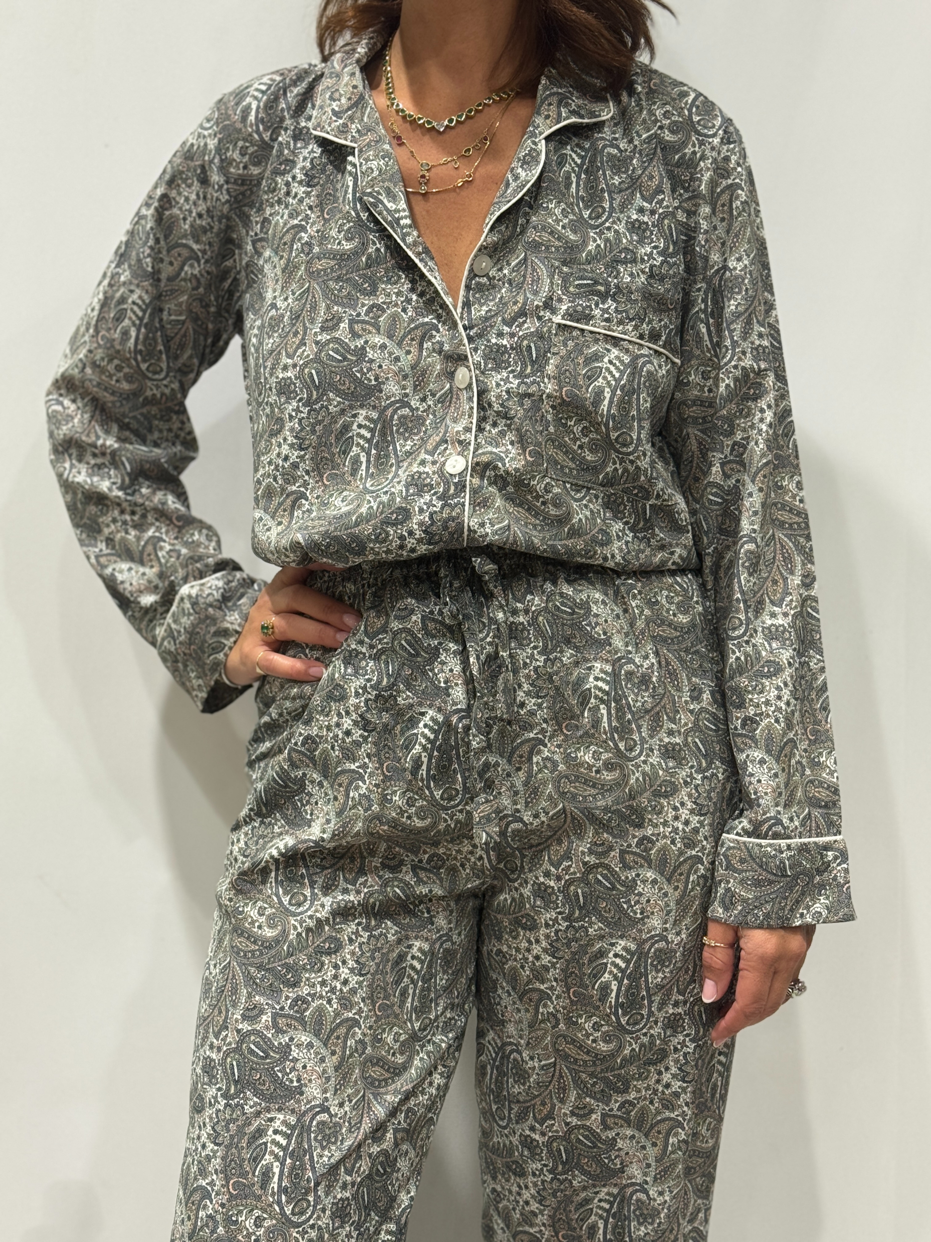 Stéphanie portant le pyjama Mira en soie aux teintes bleu-gris, vert clair et rose poudré, vue de face.