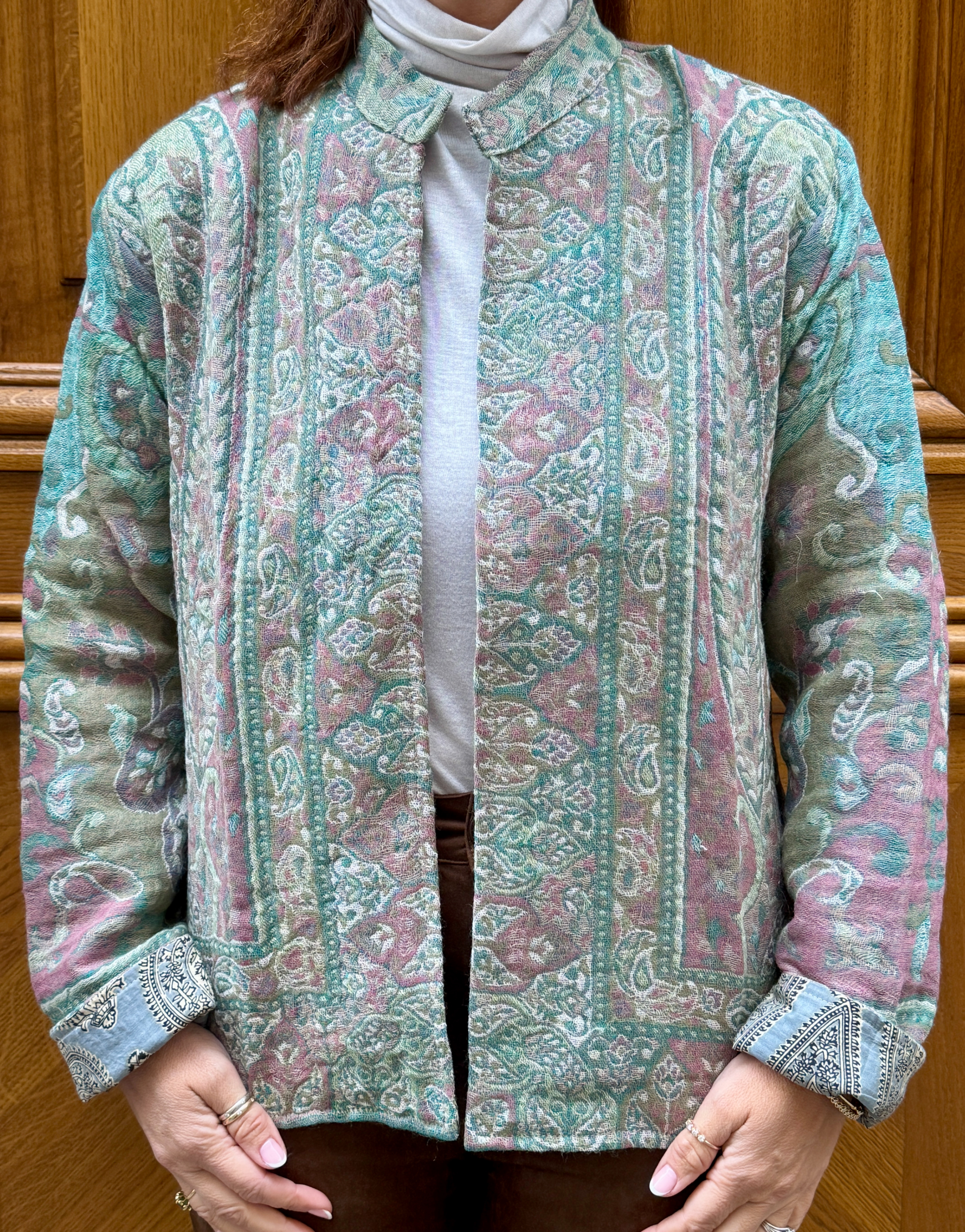 Veste Ama Micasasté portée de face, en laine aux teintes vertes et mauves.