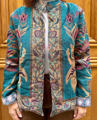 Veste Ilaa Micasasté portée de face, en laine bleu avec touches mauve et beige-jaune.