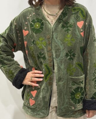 Stéphanie portant la veste Naya en velours kaki brodé à la main, col V et poches visibles.