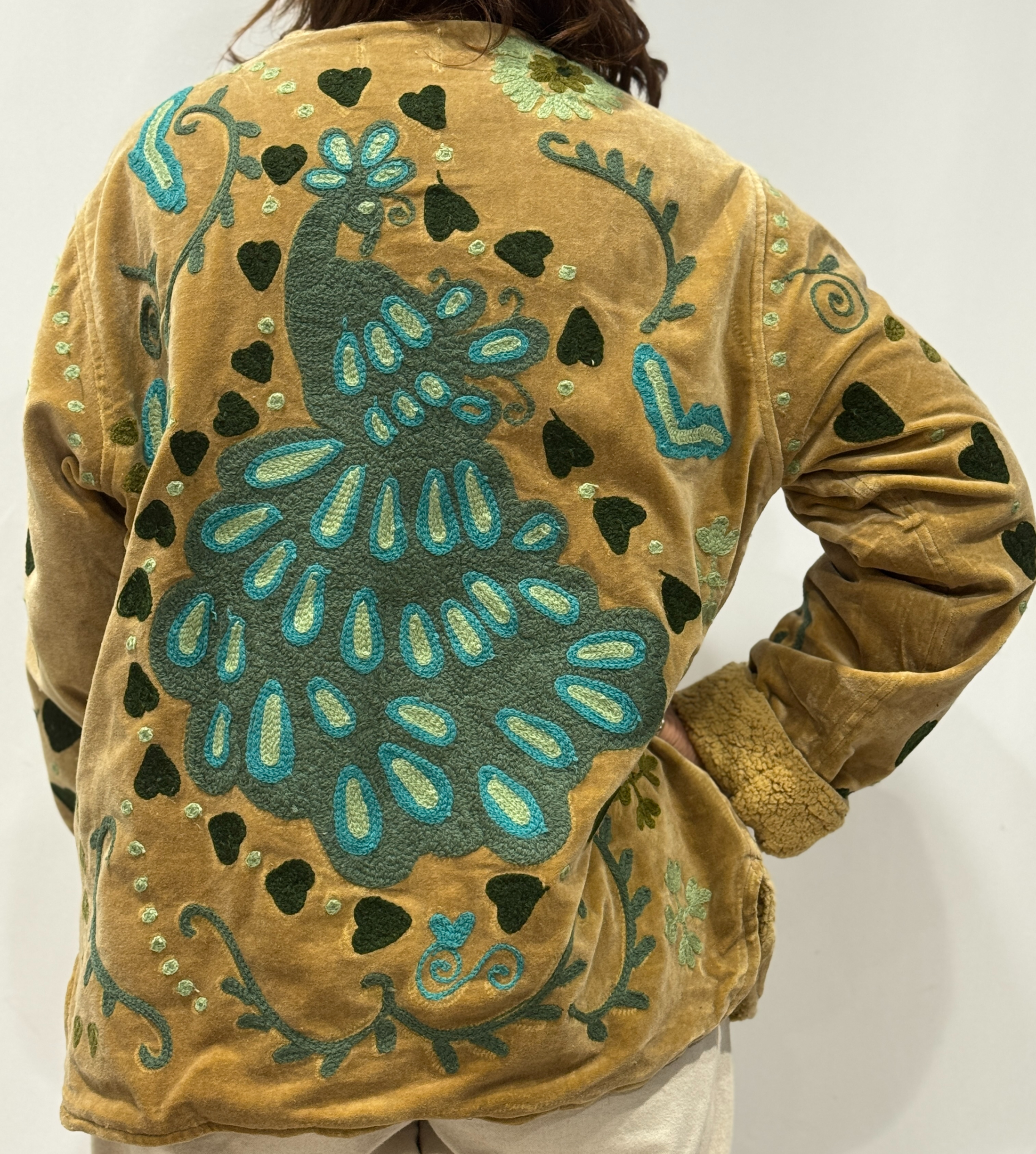 Détail du dos de la veste Raya, avec paon brodé entouré de cœurs vert kaki.