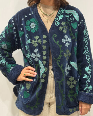 Stéphanie portant la veste Sanaï en velours bleu marine brodé à la main, col V et intérieur fourré bleu marine.