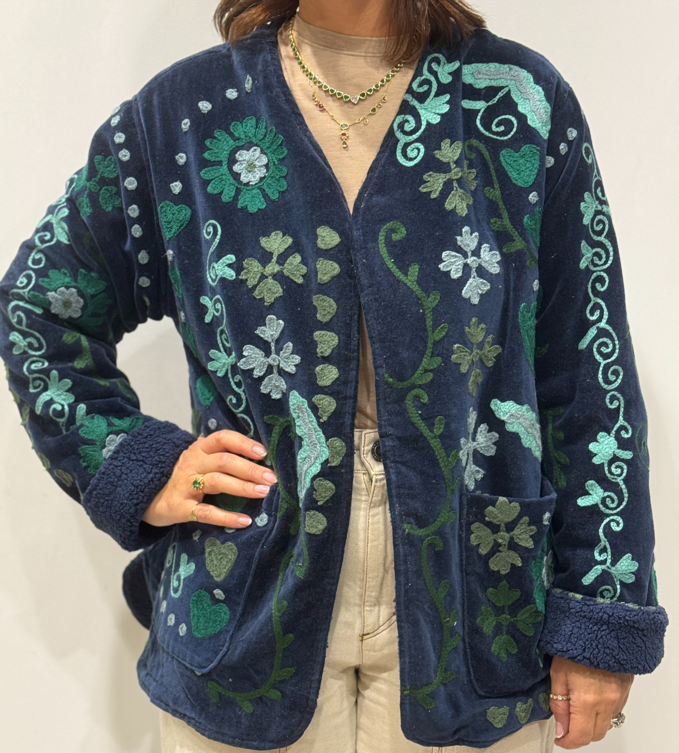 Stéphanie portant la veste Sanaï en velours bleu marine brodé à la main, col V et intérieur fourré bleu marine.