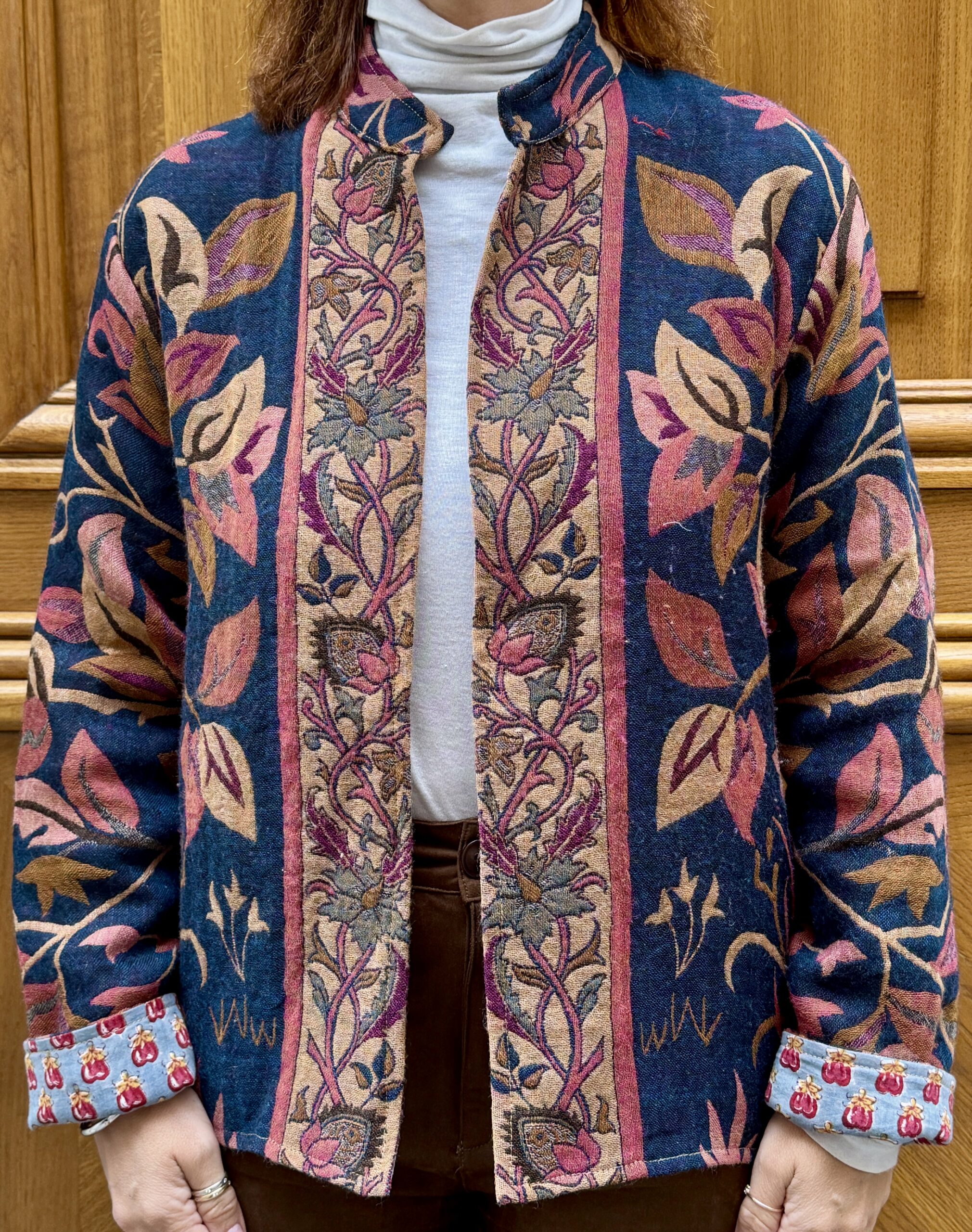 Veste Tanuja portée de face, veste en laine bleu marine aux imprimés rose et rouge