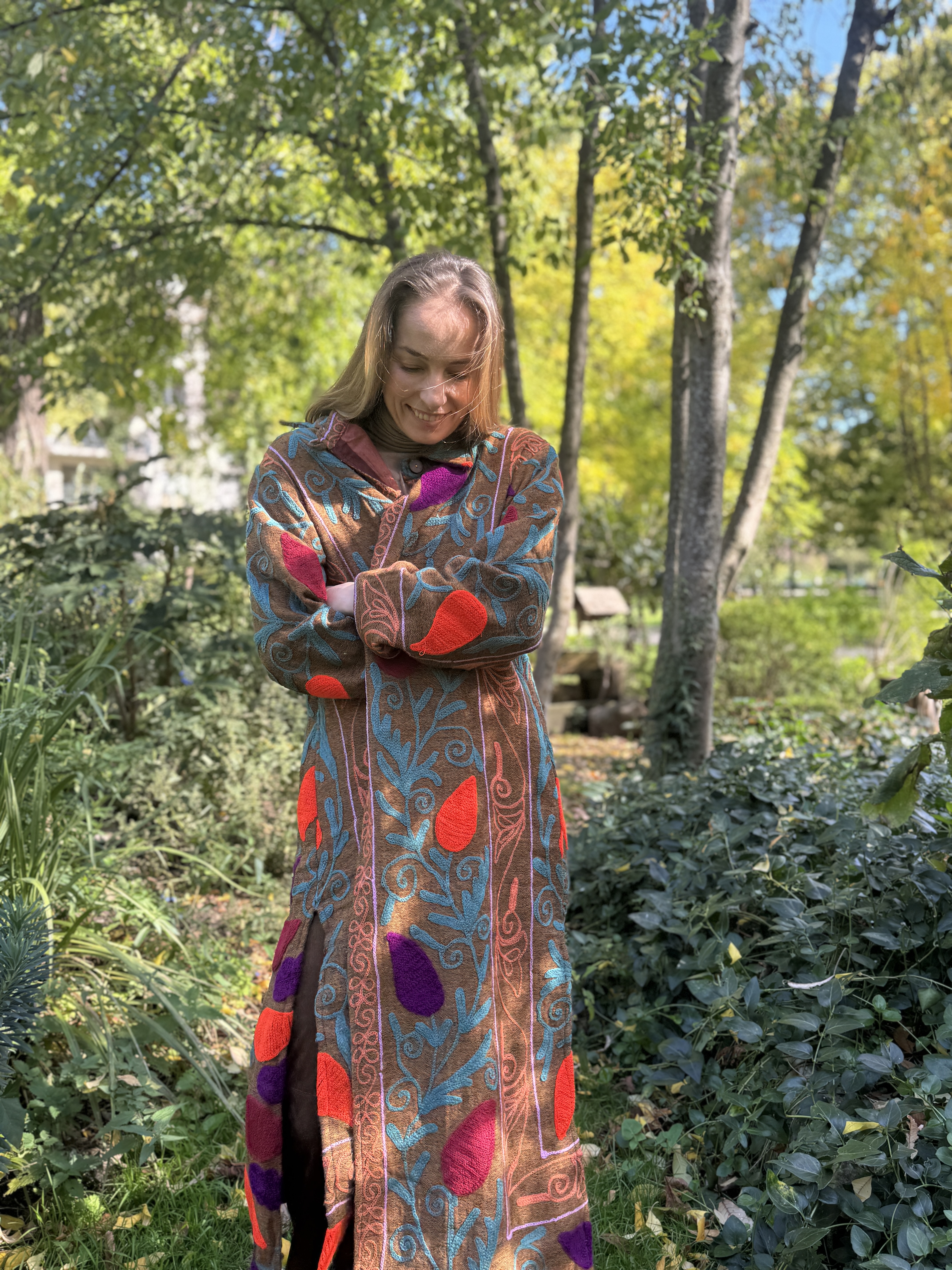 Manteau long Suzani Embrodery Velours porté par la mannequin Anya - Manteau Suzani aux imprimés orange, mauve, et bleu