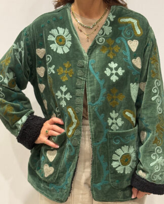 Veste Riva vue de face, en velours vert foncé brodée de motifs colorés.