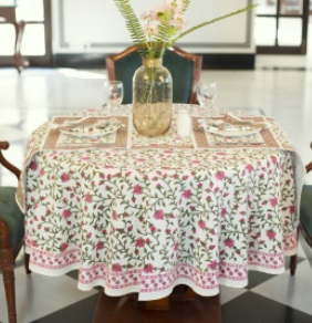 Nappe Gulshan, une nappe ronde 150 cm. Une nappe sur fond blanc avec des imprimés fleuris rose.