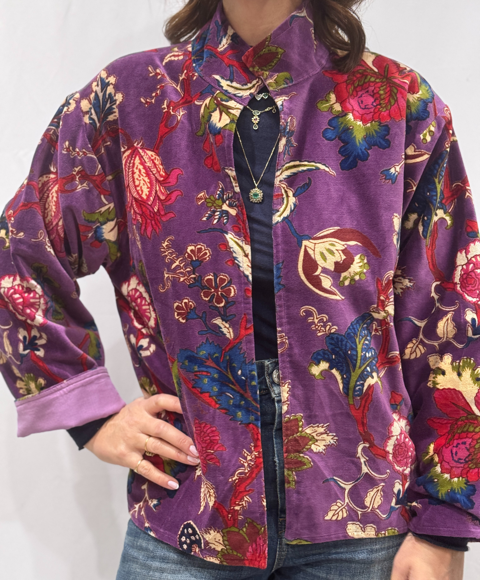 Veste Miraï, une veste en velours mauve avec des imprimés floraux rouges, verts et bleus.