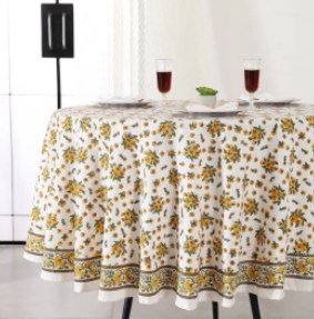 Nappe Talma, une nappe ronde de 150 cm. Une nappe blanche avec des fleurs imprimées jaunes et vertes.
