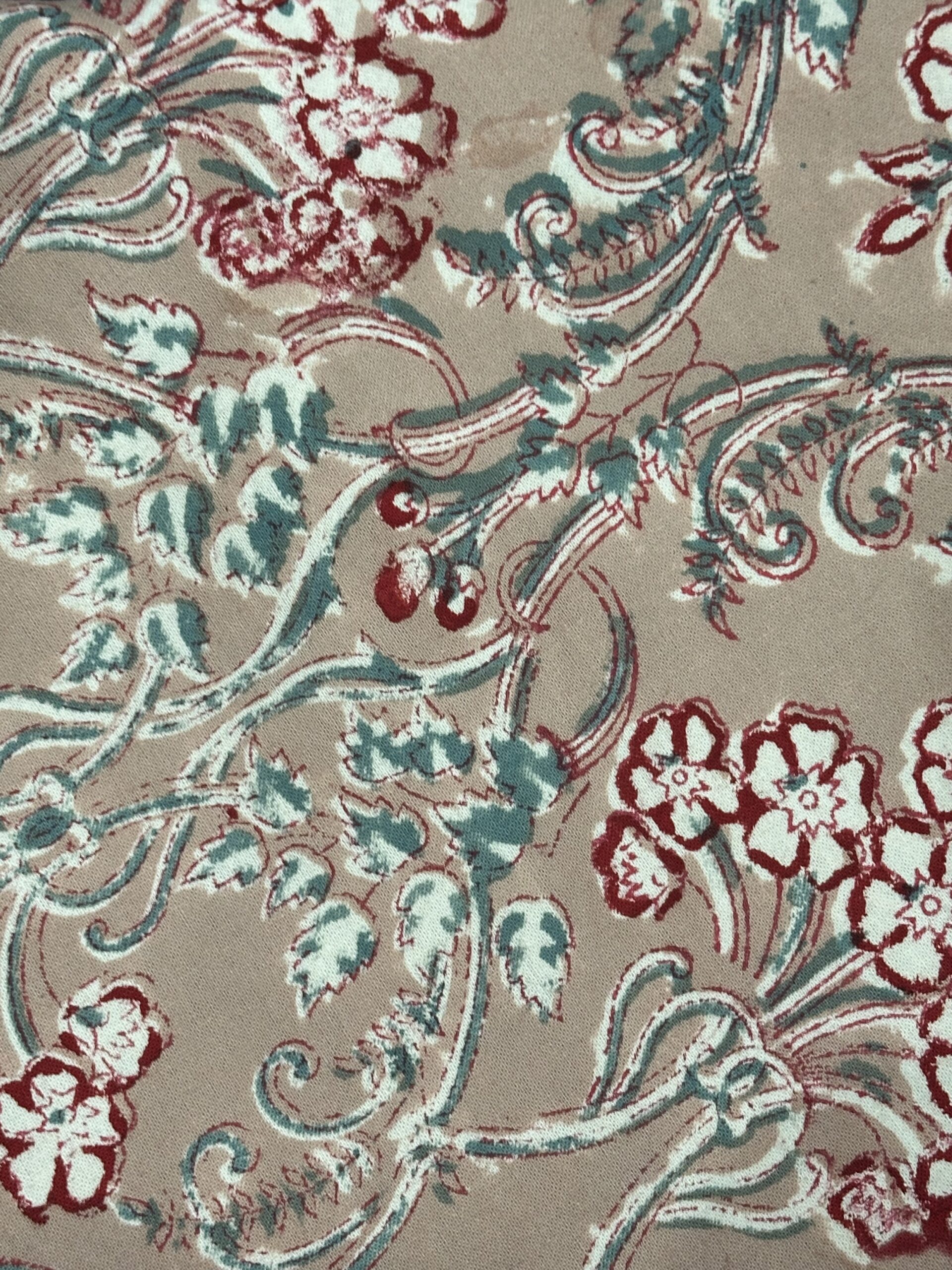 Nappe Rani, une nappe ronde sur fond vieux rose aux imprimés fleuris.