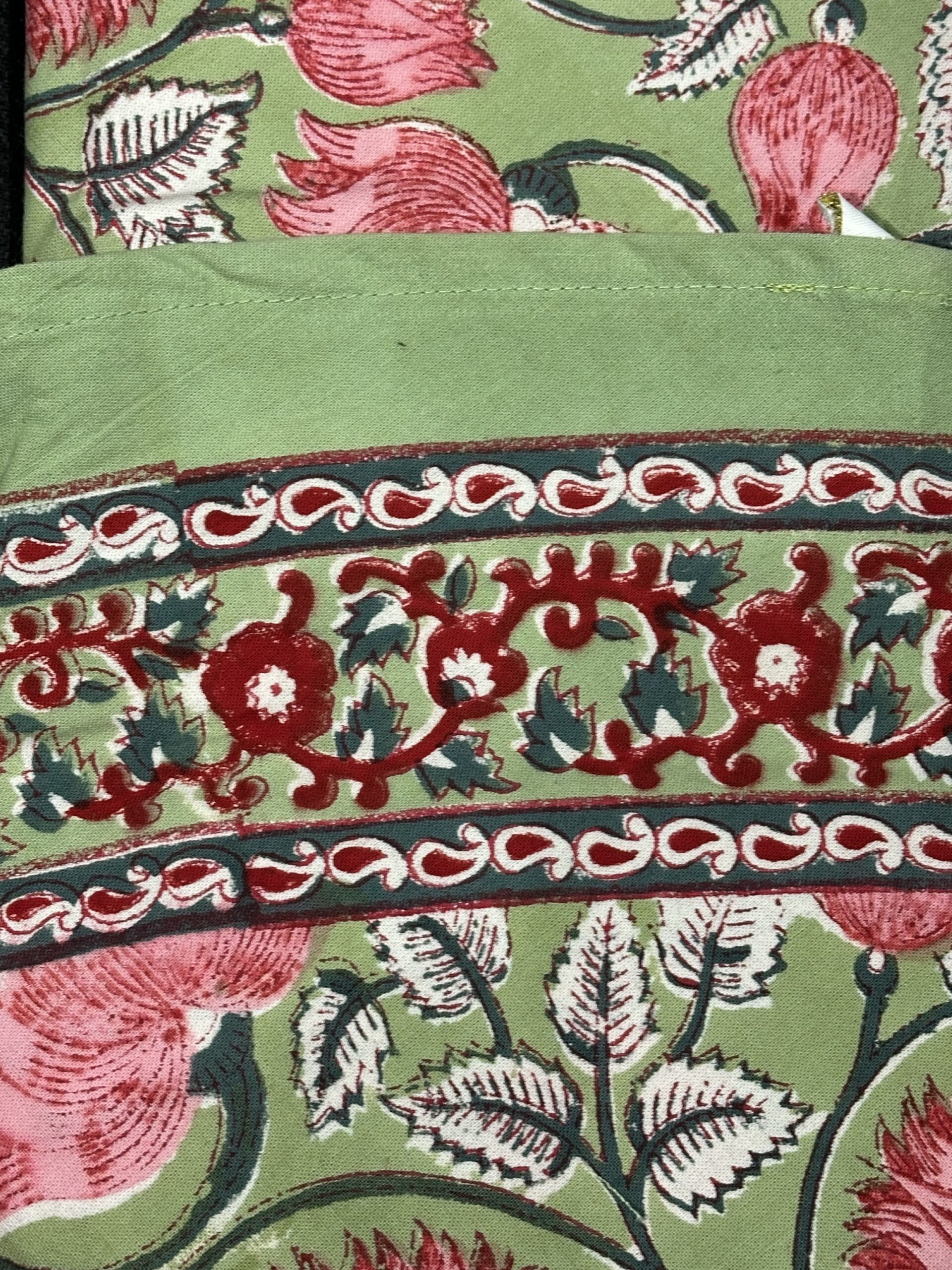 Nappe Riva, une nappe ronde de 150 cm. Une nappe verte avec des imprimés fleuris roses.