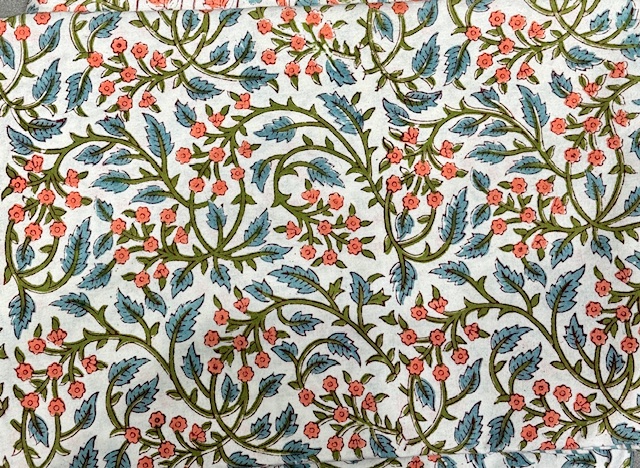Nappe Kanira, une nappe ronde de 150 cm. Une nappe aux couleurs bleus et oranges et aux imprimés fleuries.