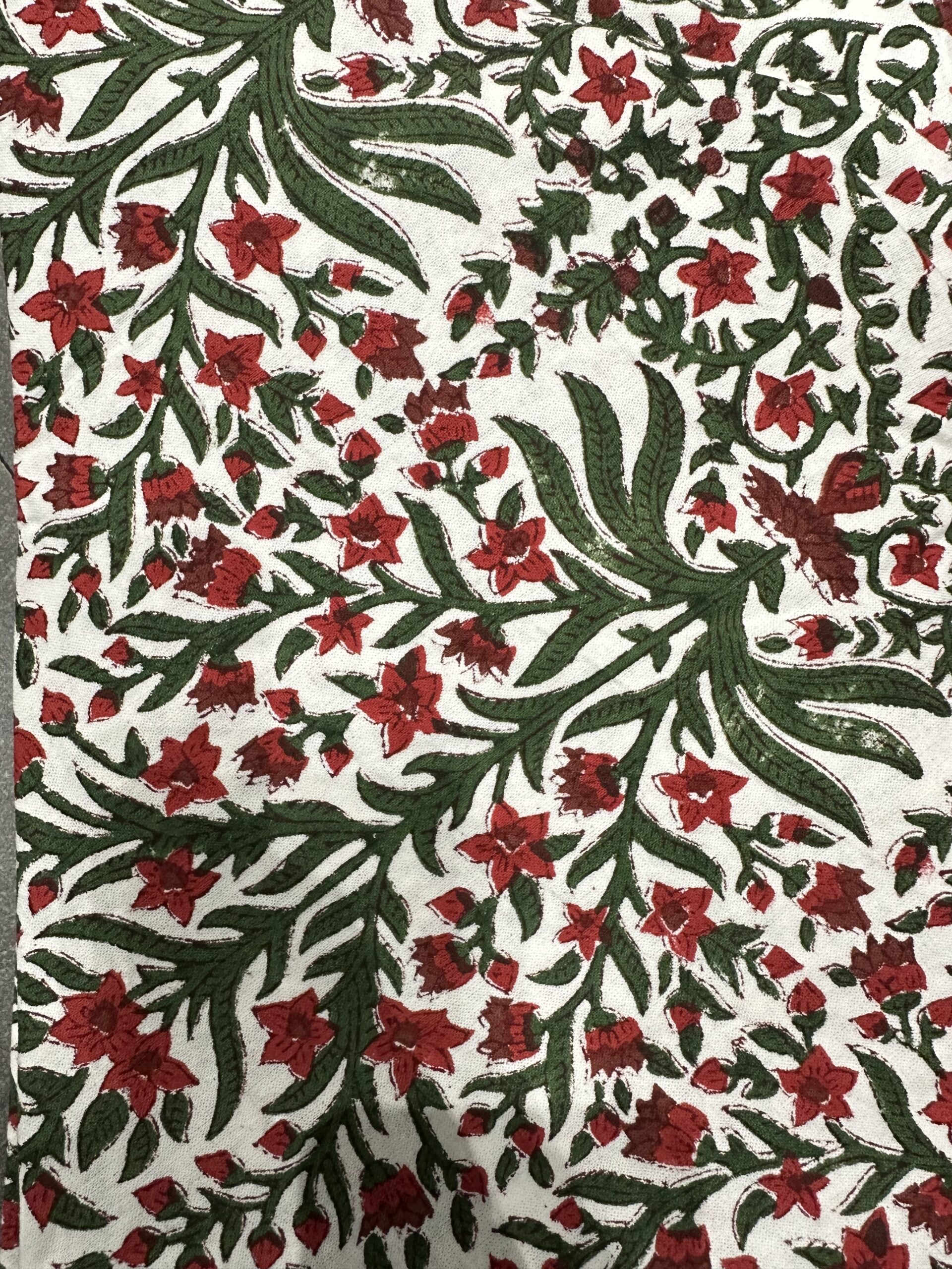 Nappe Ravika, une nappe ronde de 150 cm. Une nappe aux imprimés floraux rouge et vert.