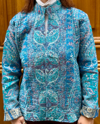 Veste Mehira, une veste en laine avec des nuances de bleus et de roses. Une veste col mao qui arrive en bas du bassin.