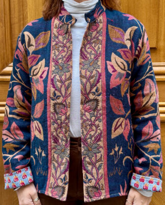 Veste Tanuja, une veste en laine avec des nuances de bleus et de roses. Une veste col mao qui arrive en bas du bassin.