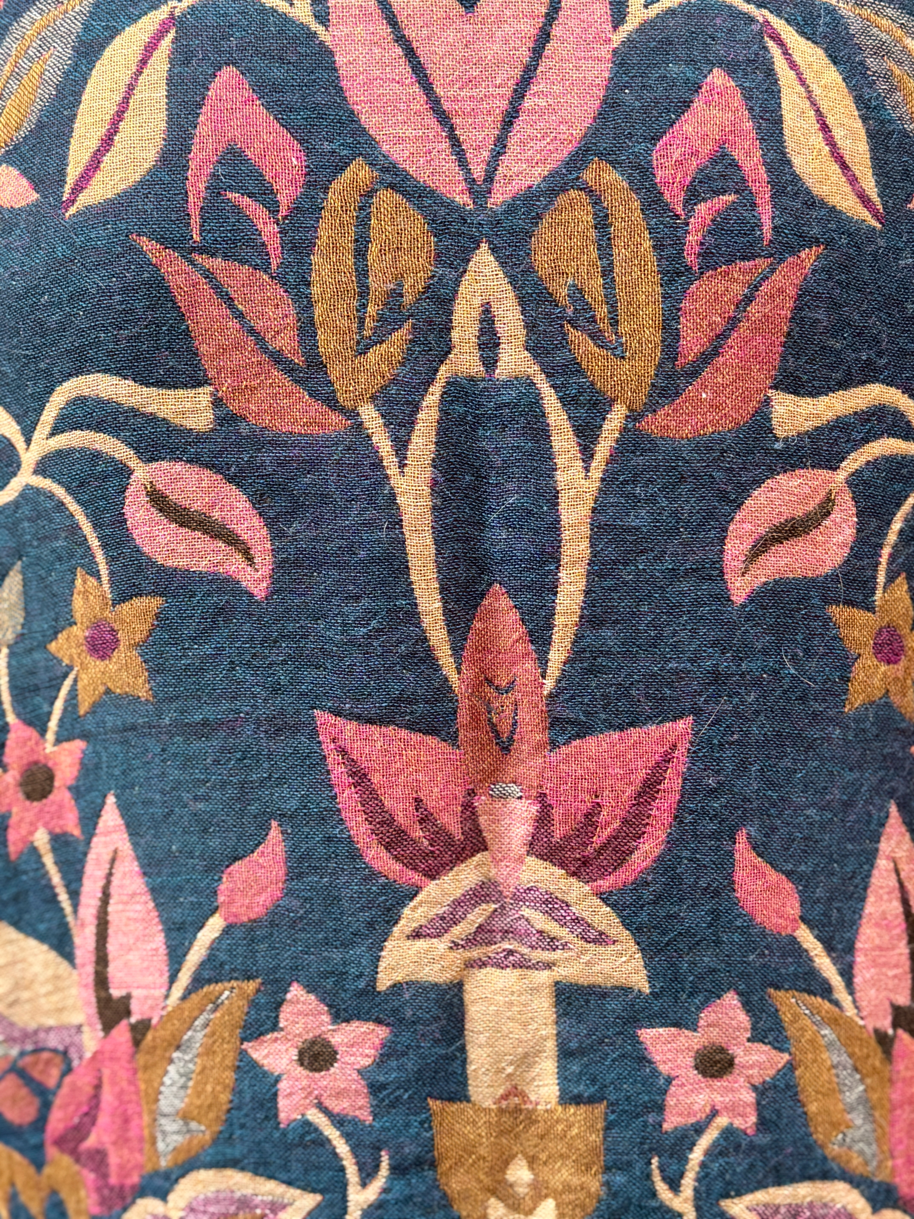 Détails Veste Tanuja, une veste en laine avec des nuances de bleus et de roses. Une veste col mao qui arrive en bas du bassin.