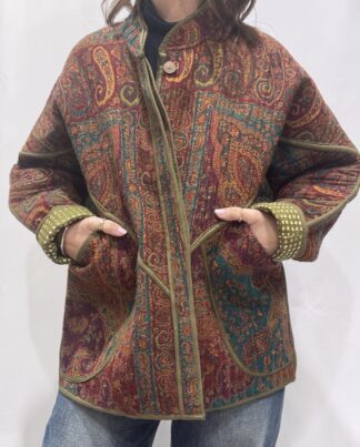 La Veste Iska, une veste en laine réversible aux imprimés de couleurs foncées : kaki, bordeaux, orange et des touches de bleus.